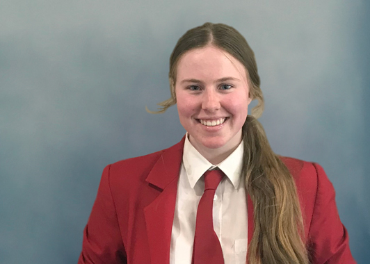 Student Maddie Hoath wearing school uniform smiling to camera Student Maddie Hoath wearing school uniform smiling to camera