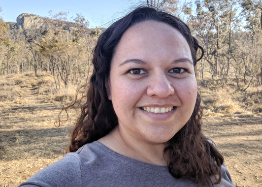 profile image of Sarah Loft with outback hills and trees in the background
