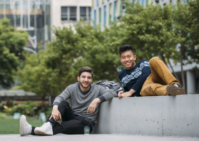 Two students sitting together looking pleased that they applied early