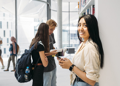 Girl in library holding phone