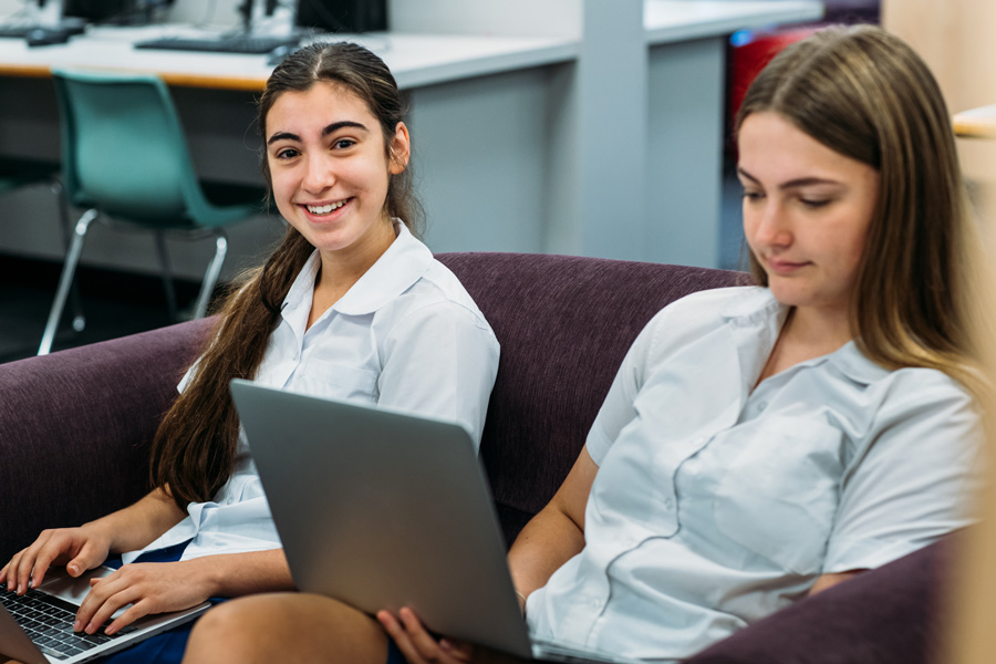 Two school girls typing on their computers Two school girls typing on their computers