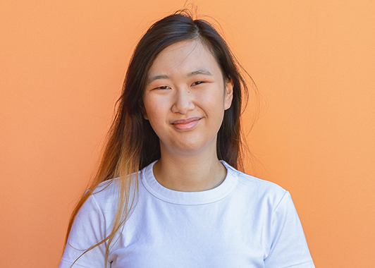 profile image of Emily Choi with bright orange background
