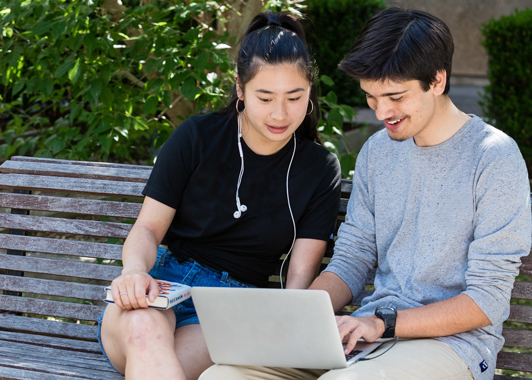 Two students looking at a laptop