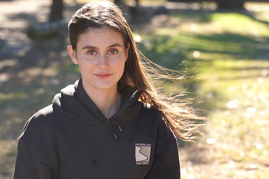 Year 10 student Josie Keevers stands outside wearing black school hoodie and smiles to camera Year 10 student Josie Keevers stands outside wearing black school hoodie and smiles to camera