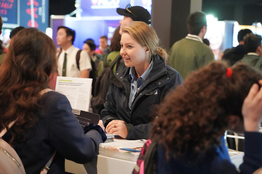 UAC Community Engagement Officer talking to a student at a careers expo